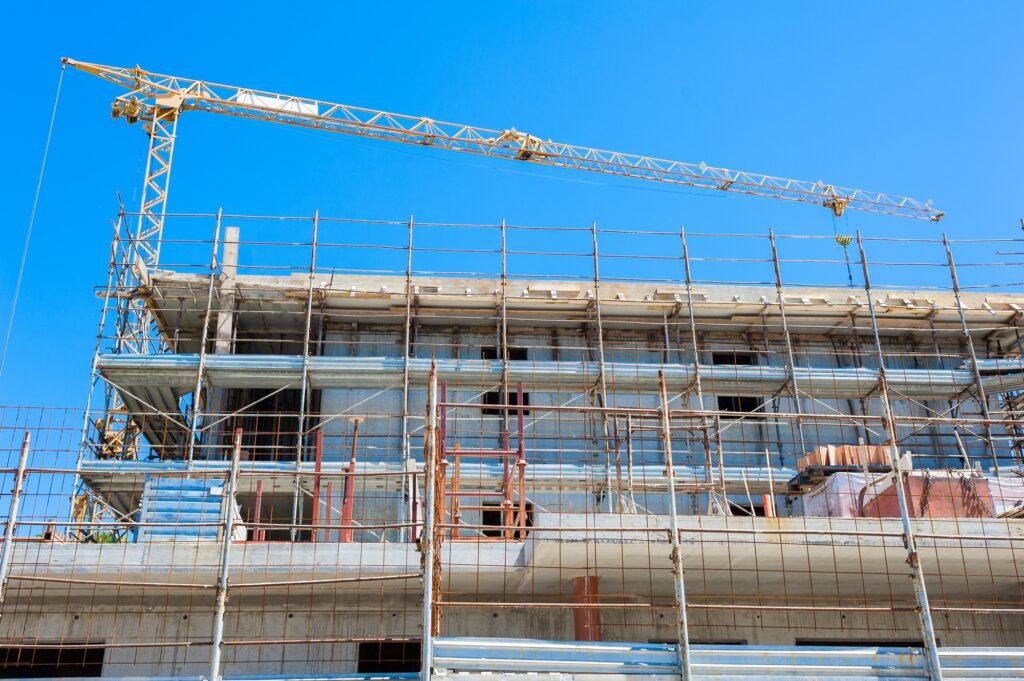 House under construction with crane and scaffolding